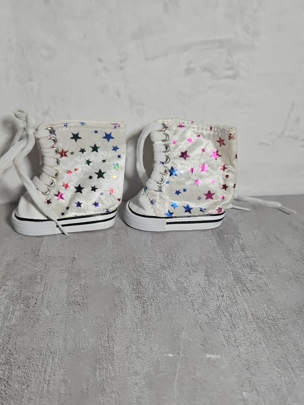 white high-top canvas doll sneakers featuring colorful holographic star pattern